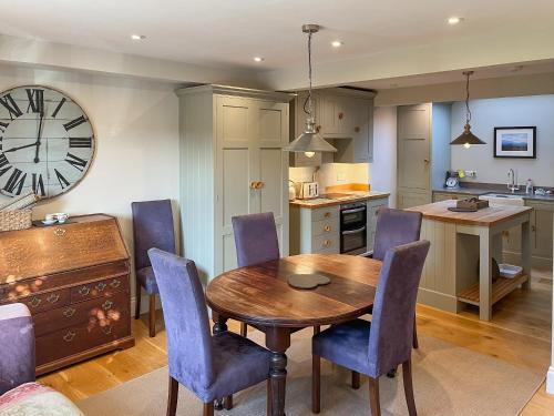 a kitchen with a table and chairs and a clock at St Anthonys in Ampleforth