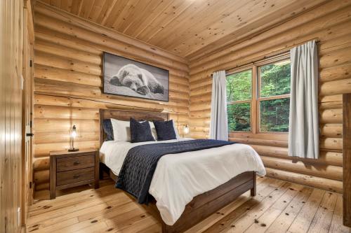 a bedroom with a bed in a log cabin at Fiddler Lake Resort - Rabbit 57 in Mille-Isles