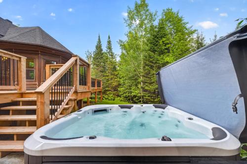 a hot tub on a deck next to a cabin at Fiddler Lake Resort - Rabbit 57 in Mille-Isles