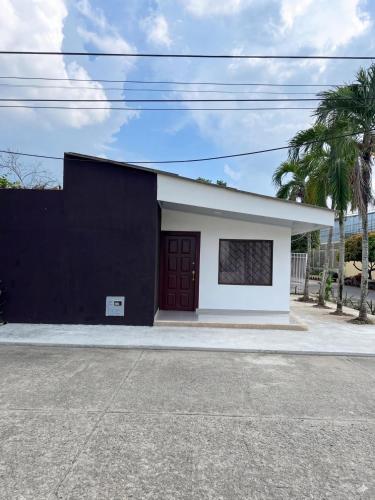 a black and white building with a red door at Cerete Apartment 111 in Cereté