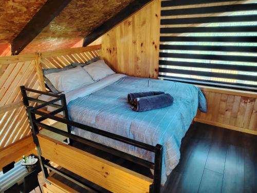 a bedroom with a bed in a wooden cabin at Cabañas Del Monte 1 in Melipeuco