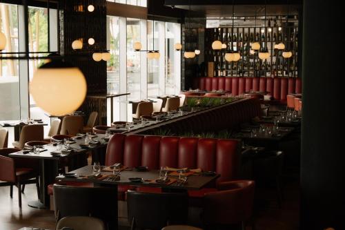 a dining room with tables and chairs and lights at Crystalbrook Bailey in Cairns