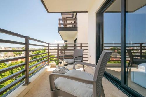 a balcony with chairs and a view of the ocean at 2Br Condo W Rooftop Pool & Backyard in Playa del Carmen