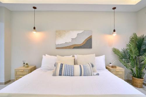 a white bedroom with a large white bed with pillows at Marbellaluxessence Beachfrontpool11Thfloor in Villas del Mar