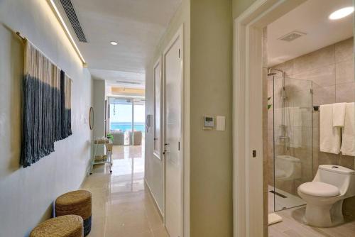 a bathroom with a toilet and a walk in shower at Marbellaluxessence Beachfrontpool11Thfloor in Villas del Mar