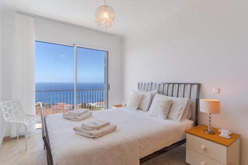 a bedroom with a bed with a view of the ocean at Villa Eldomar Heated Pool in Estreito da Calheta