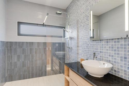 a bathroom with a white sink and a mirror at Casa Mozart Ii Sea View, Pool & Sunny Retreat in Estreito da Calheta