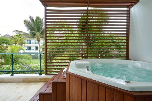 a bath tub in a room with a large window at Sublimeluxcondo Terrenas Jaccuzibeachfront in Las Terrenas