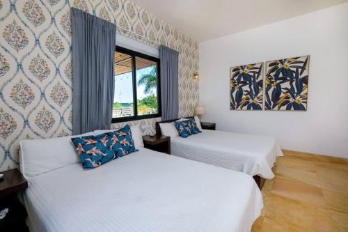 two beds in a room with a window at Beach & Mountain Villaterrenaspoolbbq6Br in Las Terrenas