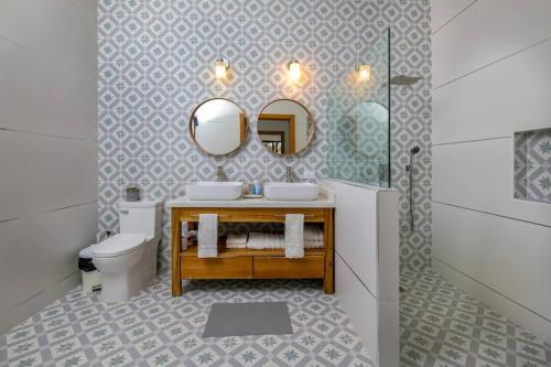 a bathroom with a sink and a mirror and a toilet at Beach & Mountain Villaterrenaspoolbbq6Br in Las Terrenas