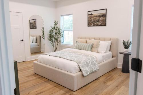 a white bedroom with a bed and a mirror at Pensacola Florida in Pensacola