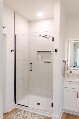 a white bathroom with a glass shower stall at Pensacola Florida in Pensacola
