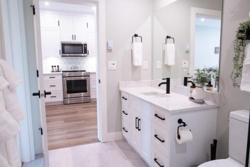 a white kitchen with a sink and a stove at New 1 Bed Condo with Mtn Views in Harrison Hot Springs