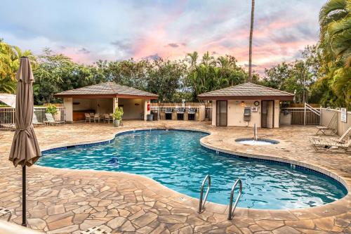 a pool at a resort with an umbrella at Beachside Maui studio with pool & hot tub access in Wailea