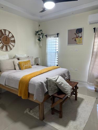 a bedroom with a bed and a clock on the wall at Serenity Villas in Ocho Rios