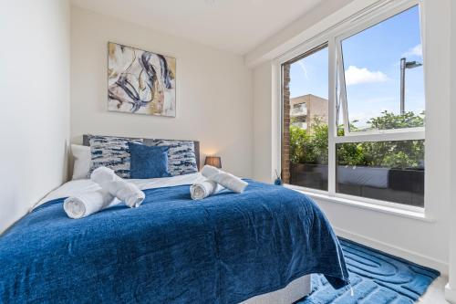 a bedroom with a blue bed with a window at 3 Bed Duplex, Pool Table, 4 Stops to Wembley in Hatch End