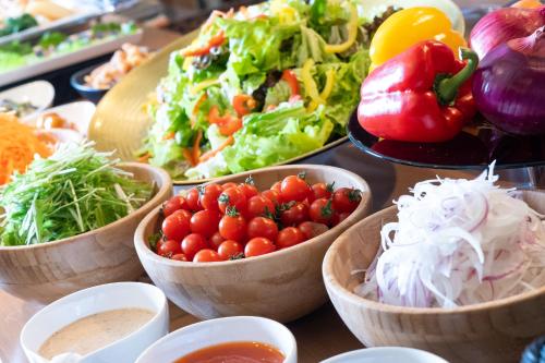 a table with bowls of vegetables and other foods at HOTEL MYSTAYS Tachikawa in Tachikawa