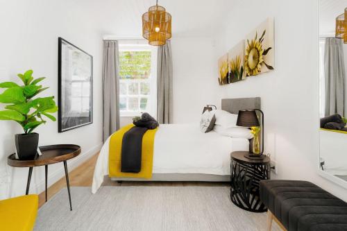 a bedroom with a bed and a table and a couch at Quiet Central Home Near Newlands Cricket in Cape Town