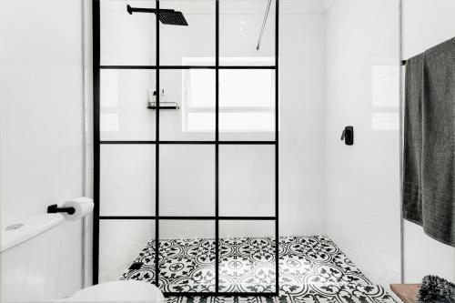 a bathroom with a glass shower door with a pillow at Quiet Central Home Near Newlands Cricket in Cape Town