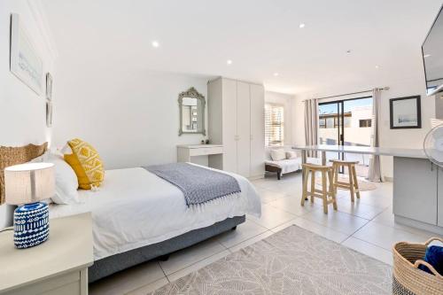 a bedroom with a king sized bed and a kitchen at Coast Unit 5, Bright Escape By Langebaan Lagoon in Langebaan