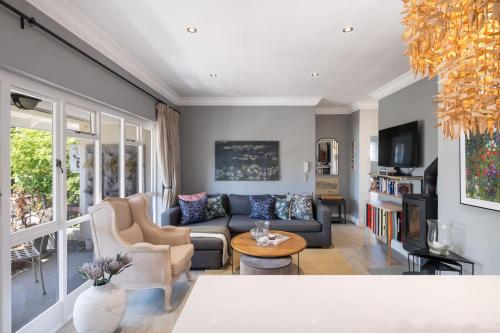 a living room with a couch and a table at Quiet Garden Flat Near Kenilworth Centre in Cape Town