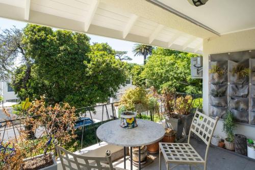 a patio with a table and chairs on a balcony at Quiet Garden Flat Near Kenilworth Centre in Cape Town