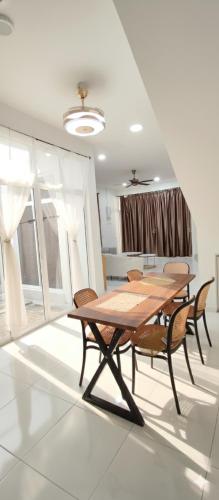 a dining room with a wooden table and chairs at Eden Vista in Kuantan