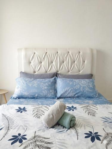 a bed with blue and white sheets and pillows at Eden Vista in Kuantan