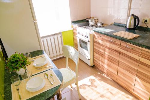 uma pequena cozinha com uma mesa e um fogão em Poltava Green Apartments em Poltava