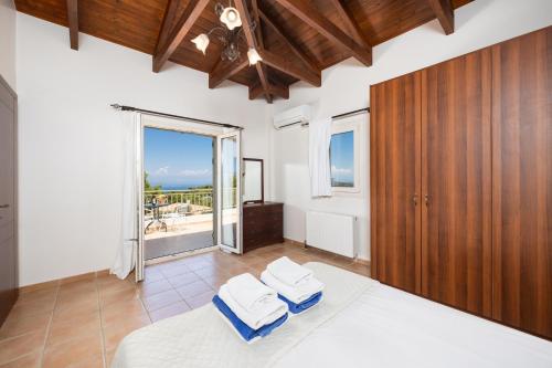 a bedroom with a bed and a large window at Villa Eudora in Tsoukalades