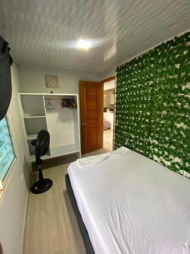 a bedroom with a bed and a green wall at La posada in Nuquí