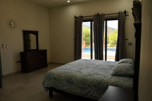 a bedroom with a bed and a mirror and a window at Casa de Cuatro Vientos in Álamos