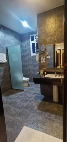 a bathroom with a sink and a mirror and a toilet at فندق جون in Abha