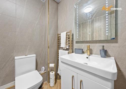 a bathroom with a white sink and a toilet at 2Br House I Sleeps 4 I Cumbernauld in Cumbernauld