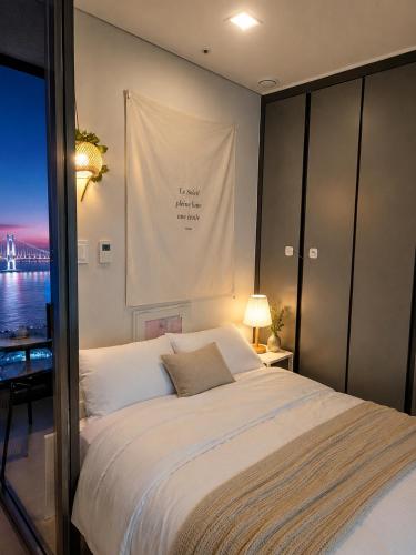 a bedroom with a bed with a sign on the wall at Crystal Ocean House 무료주차 in Kwangan-dong