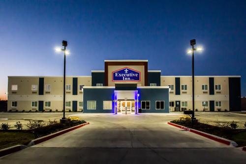 a large building with a lit up sign on it at Executive Inn Fort Worth West in Fort Worth