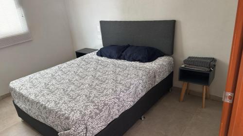 a bedroom with a bed with a gray comforter at Natura suite's & eventos in Guadalajara