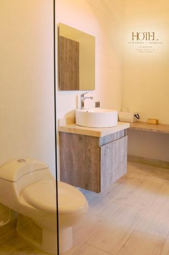 a bathroom with a toilet and a sink at Hotel Madera y Tierra in Tame