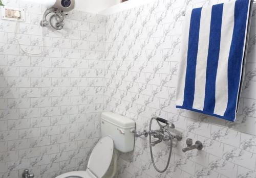 a bathroom with a toilet and a blue and white towel at SoulStay Vrindavan in Mathura
