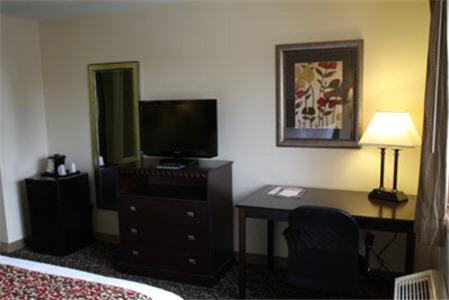 a hotel room with a desk and a television at Valley Inn Sanford Medical Center in Sioux Falls