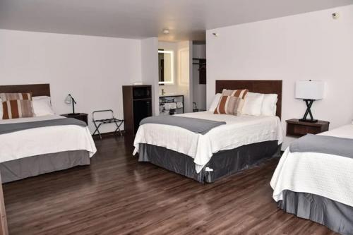 a hotel room with two beds and wooden floors at Eagle Peak Lodge & Cabins in Ashton