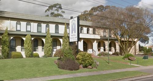 a large white building with a sign in front of it at Hotel Cavalier in Wantirna South