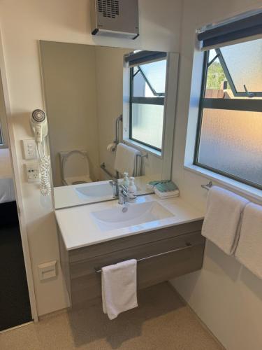 a bathroom with a sink and a mirror at Bay Cottages in Kaikoura