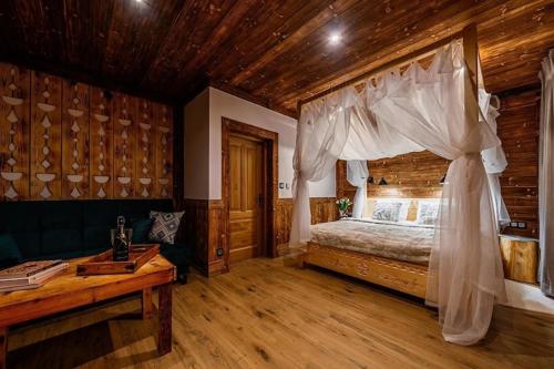 a bedroom with a bed and a wooden ceiling at A large mountain-style house with a spa area in Murzasichle