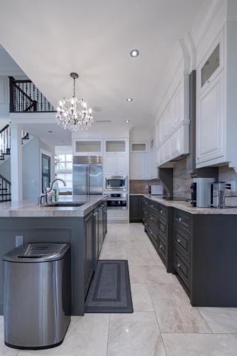 a large kitchen with white cabinets and a chandelier at Private Room in Richmond in Richmond