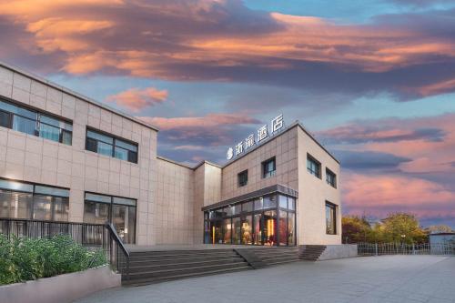 a building with a cloudy sky in the background at BOLE ZHEYU Hotel in Bole