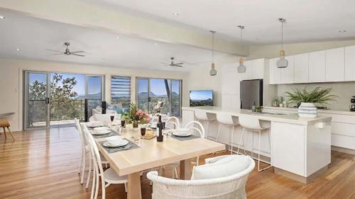 a kitchen and dining room with a table and chairs at Hamptons By The Bay in Nelson Bay