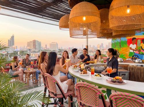 a group of people sitting at a table in a restaurant at The Fig Lobby Bangkok in Bangkok