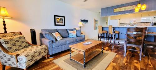 a living room with a couch and a kitchen at Check In, Chill Out - Annies Surf Shack Awaits! in Kahana