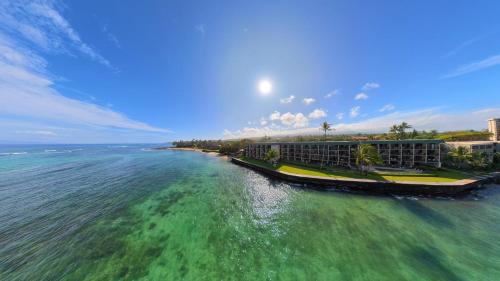 an aerial view of a resort on the ocean at Check In, Chill Out - Annies Surf Shack Awaits! in Kahana